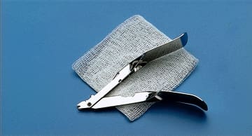 A pair of scissors on top of a piece of cloth.