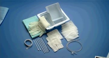 A tray of surgical supplies and bandages on a blue surface.