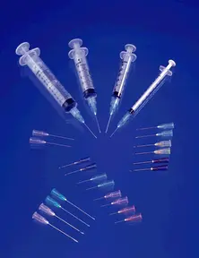 A group of syringes and needles on a blue background.