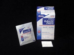 A package of gauze pads on a black surface.