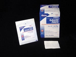 A package of gauze pads on a black surface.