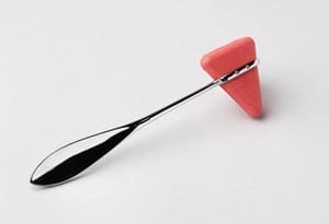 A spoon with a pink handle on a white surface.