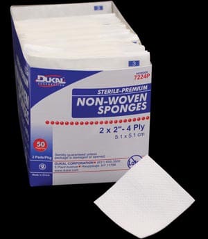 A box of non woven sponges on a black background.