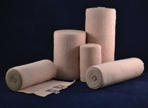 Four rolls of bandages on a blue background.