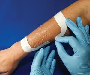 A person is applying a bandage to a person's arm.