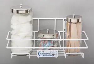 A white bathroom storage rack with three jars and a toothbrush holder.