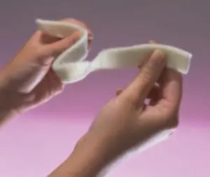 A person is holding a piece of white felt.