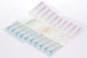 A plastic container with a variety of different colored syringes.