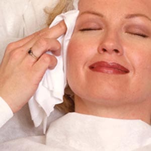 A woman laying on a bed with her eyes closed.