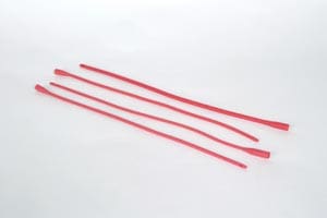 A group of red plastic straws on top of a white surface.