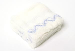 A stack of white cloth diapers on a white surface.