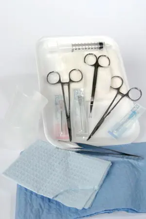 A tray with surgical tools and a blue cloth.