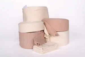 Four rolls of beige bandages on a white background.