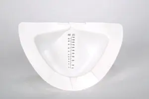 A white bowl with an empty measuring cup inside of it.