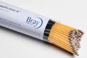 Bray match sticks in a tube on a white surface.