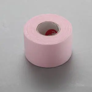 A roll of pink tape on a grey surface.