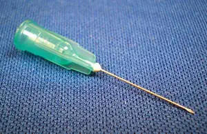 A green needle on a blue cloth.