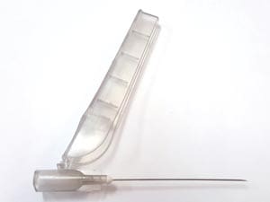 A plastic syringe on a white surface.