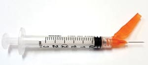 A syringe with an orange syringe.