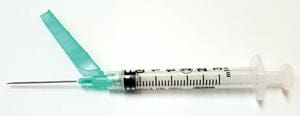 A syringe with a green needle on it.