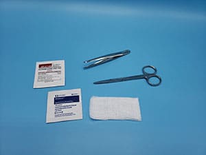 A pair of scissors, bandages and a bandage on a blue surface.