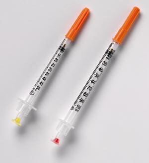 Two syringes on a white surface.