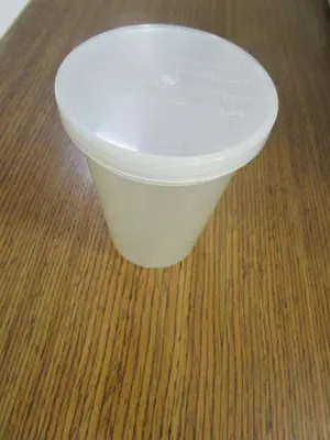 A white cup sitting on top of a wooden table.