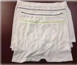 Three pairs of white boxer shorts on a table.