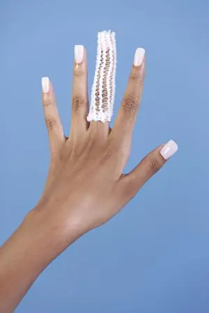 A woman's hand holding a crocheted finger ring.