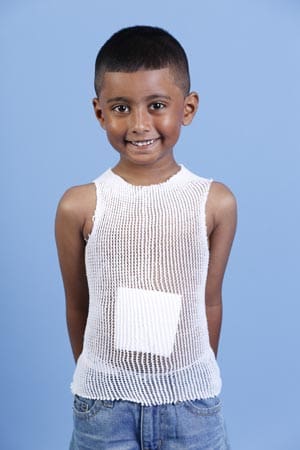 A young boy wearing a white tank top.