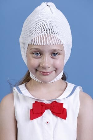 A young girl wearing a white knitted hat.