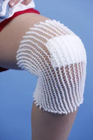 A woman's knee with a white bandage on it.