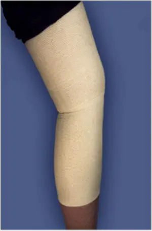 A woman's leg with a beige knee sleeve.