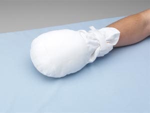 A person with a white glove on a bed.