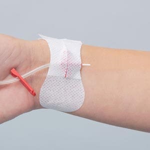 A person's wrist with a syringe attached to it.