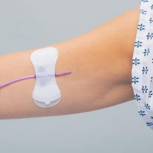 A woman's arm with a syringe attached to it.