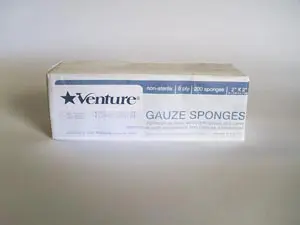 A box of venture gauze sponges on a white surface.