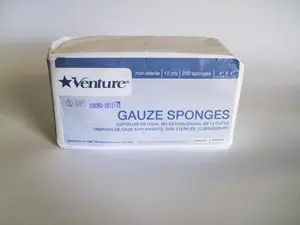 A box of gauze sponges on a white surface.