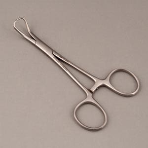 A pair of surgical scissors on a gray surface.