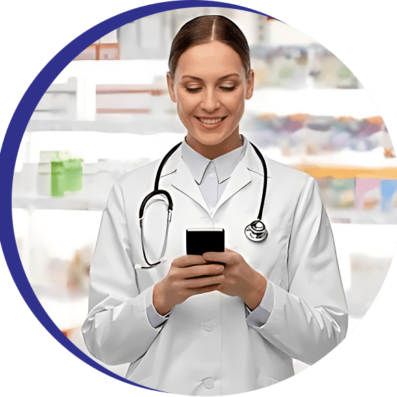 A woman in a lab coat is holding a cell phone in front of a pharmacy.