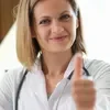 A female doctor giving a thumbs up.