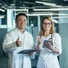 Two doctors giving thumbs up in an office.